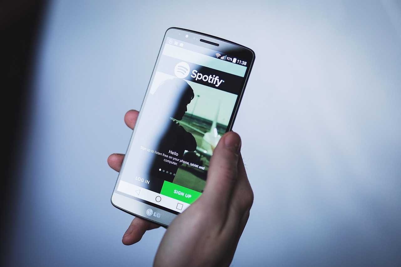 Hand holding phone showing spotify interface
